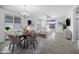 Dining space with stylish table set and neutral tones adjacent to open-concept living room at 40015 W Crane Dr, Maricopa, AZ 85138