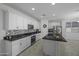 Full view of modern kitchen with an island, stainless appliances, white cabinets, and tile floors at 40015 W Crane Dr, Maricopa, AZ 85138