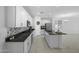 Large modern kitchen with white cabinets, dark countertops, a center island, and tile flooring at 40015 W Crane Dr, Maricopa, AZ 85138