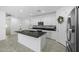Modern open kitchen with an island, white cabinets, stainless appliances, and tile floors at 40015 W Crane Dr, Maricopa, AZ 85138
