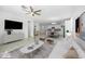 Open-concept living space boasts neutral colors, a ceiling fan, and flows into kitchen area at 40015 W Crane Dr, Maricopa, AZ 85138