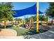 Community playground featuring a slide, climbing structures, and a shaded canopy for sun protection at 40015 W Crane Dr, Maricopa, AZ 85138