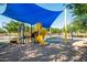 A modern playground with a spiral slide, climbing equipment, and cushioned ground for a safe play area at 40015 W Crane Dr, Maricopa, AZ 85138