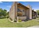 Exterior of a two-story stucco condo featuring a balcony, well-maintained landscaping, and lush green grass at 5525 E Thomas Rd # N1, Phoenix, AZ 85018
