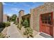 Exterior view of the walkway with desert landscaping and an inviting red door to the unit at 5525 E Thomas Rd # N1, Phoenix, AZ 85018