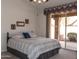 This bedroom features a serene view of the outdoors through a large sliding glass door to the backyard patio at 8598 E Saguaro Blossom Rd, Gold Canyon, AZ 85118