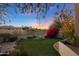 Landscaped backyard with artificial turf and red flowers at 1535 E Calavar Dr, Phoenix, AZ 85022