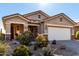 Tan house with a two-car garage and nicely landscaped yard at 31627 N Poncho Ln, San Tan Valley, AZ 85143