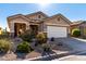 Tan house with a large garage and nicely landscaped front yard at 31627 N Poncho Ln, San Tan Valley, AZ 85143