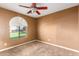 Light brown bedroom with carpet and an arched window at 4343 E Downing St, Mesa, AZ 85205