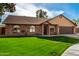 Brick home with arched windows, 2-car garage, and grassy yard at 4343 E Downing St, Mesa, AZ 85205