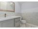 Modern bathroom with gray vanity, white toilet, and marble-style tile at 13924 E Windstone Trl, Scottsdale, AZ 85262