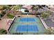 Two well-maintained tennis courts with surrounding landscape at 1950 N 142Nd Ave, Goodyear, AZ 85395