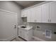 Bright laundry room with white cabinets, countertop sink, and washer/dryer hookups at 28205 N 213Th Dr, Wittmann, AZ 85361