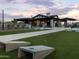 Recreational area featuring a walkway, benches, cornhole, manicured lawn, and a clubhouse in the background at 3375 E Audrey Dr, San Tan Valley, AZ 85143