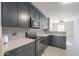 Modern kitchen with dark cabinetry, quartz countertops, and patterned tile floor at 36224 W Picasso St, Maricopa, AZ 85138