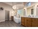 Modern bathroom features a soaking tub, wooden cabinets, and decorative glass block at 15155 E Westridge Dr, Fountain Hills, AZ 85268