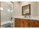 Bathroom with marble backsplash in shower, wood vanity and large framed mirror at 15155 E Westridge Dr, Fountain Hills, AZ 85268