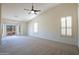 Bright living room features a ceiling fan, neutral carpet, and a sliding door to the outside at 16068 W Edgemont Ave, Goodyear, AZ 85395