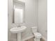 Stylish powder room featuring a pedestal sink, modern fixtures, and neutral wall color at 17666 W Pierson St, Goodyear, AZ 85395