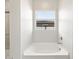 Elegant bathroom featuring a soaking tub nestled beneath a window with serene outdoor views at 17666 W Pierson St, Goodyear, AZ 85395