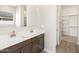 Modern bathroom showcasing double sinks, white countertops, and a view into the walk-in closet at 17666 W Pierson St, Goodyear, AZ 85395