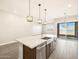 Bright kitchen island with stainless steel sink, overlooking sliding glass doors at 17666 W Pierson St, Goodyear, AZ 85395