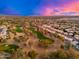 Aerial view of homes surrounding a golf course at sunset at 2257 W Periwinkle Way, Chandler, AZ 85248