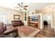 Living room with leather sofas, a stone fireplace, and hardwood floors at 2257 W Periwinkle Way, Chandler, AZ 85248