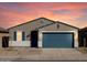 Charming single-story home showcasing a well-maintained front yard and a blue two-car garage at 37028 W Prado St, Maricopa, AZ 85138