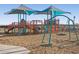 Neighborhood playground featuring swings, climbing frames, and sunshades on a mulch base at 37028 W Prado St, Maricopa, AZ 85138