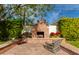 Brick patio with fireplace, seating area, and lush landscaping at 6030 E Calle Del Sud St, Scottsdale, AZ 85251