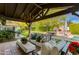 Covered patio with seating area, adjacent to the pool and outdoor kitchen at 6030 E Calle Del Sud St, Scottsdale, AZ 85251