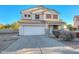 Two-story house with a white exterior, landscaping, and a two-car garage at 10350 W Alvarado Rd, Avondale, AZ 85392