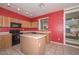 Kitchen with island, wood cabinets, and back door access at 10350 W Alvarado Rd, Avondale, AZ 85392