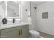 Modern bathroom with green vanity, white subway tile shower, and patterned floor at 1829 E Amelia Ave, Phoenix, AZ 85016