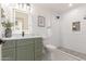 Modern bathroom with green vanity, white subway tile shower, and patterned floor at 1829 E Amelia Ave, Phoenix, AZ 85016