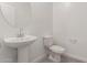 Clean bathroom with pedestal sink, toilet, and grey tile floor at 31730 N Waddle Ln, San Tan Valley, AZ 85143