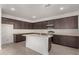 Modern kitchen with dark cabinets and center island at 31730 N Waddle Ln, San Tan Valley, AZ 85143