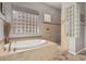 Spa-like bathroom with soaking tub, walk-in shower, and glass block accents at 3415 E Sports Dr, Gilbert, AZ 85298