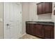 Laundry room with dark wood cabinets and granite countertop at 3415 E Sports Dr, Gilbert, AZ 85298