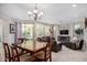 Casual dining area with wood table and chairs near living room and sliding doors at 97 E Alcatara Ave, San Tan Valley, AZ 85140