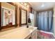 Bathroom with double sinks, wood framed mirrors and a shower at 30247 N 164Th St, Scottsdale, AZ 85262