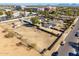 Wide aerial view of the home, outbuildings, and perimeter fence, with city buildings in the background at 3740 E Edna Ave, Phoenix, AZ 85032