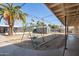 Backyard with a swing and desert landscaping, all under a metal pergola roof at 3740 E Edna Ave, Phoenix, AZ 85032