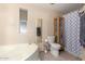 Bright bathroom with a soaking tub, tile floors, and a separate toilet room at 3740 E Edna Ave, Phoenix, AZ 85032