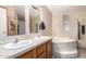 Bathroom featuring double sinks, a soaking tub, and a shower with a grey patterned curtain at 3740 E Edna Ave, Phoenix, AZ 85032