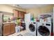 Bright laundry room with tile backsplash, cabinet space, and modern washer and dryer at 3740 E Edna Ave, Phoenix, AZ 85032