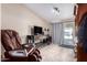 Cozy living room with a comfortable armchair, a TV, and tiled floors at 3740 E Edna Ave, Phoenix, AZ 85032