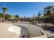 Empty in-ground pool surrounded by desert landscaping and a black iron fence at 3740 E Edna Ave, Phoenix, AZ 85032